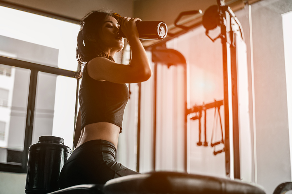 woman working out and drinking an infused sports drink