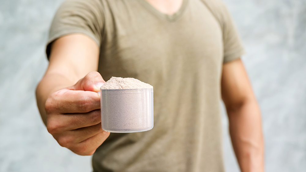 a man holding a scooper with electrolyte powder